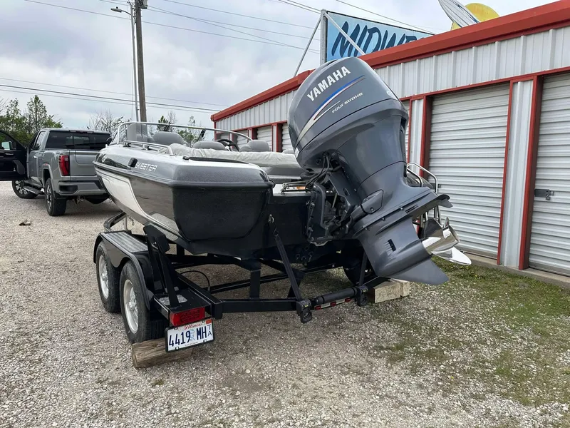 Slide: The Image of 2009 Skeeter SL 190 boat with Yamaha motor on trailer, parked near storage units. - 29