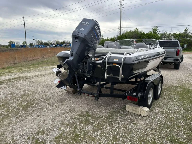 Slide: The Image of 2009 Skeeter SL 190 boat on trailer with Yamaha 150 engine, parked outdoors. - 4