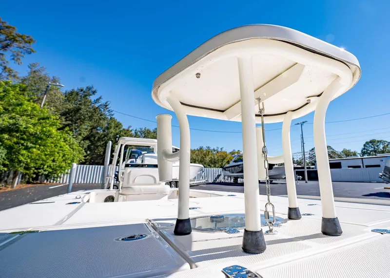 Slide: The Image of 2024 Spyder FX 19 Vapor boat deck with seating and rod holders under clear blue sky. - 22