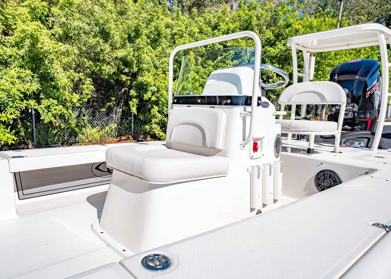 Slide: The Image of 2024 Spyder FX 19 Vapor boat interior with seating and console, surrounded by greenery. - 6