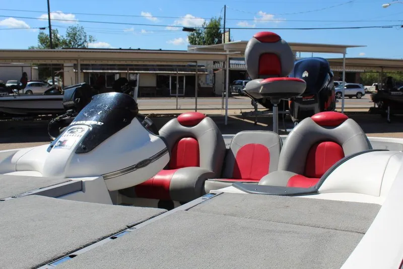 Slide: The Image of 2007 Ranger Z21 boat with red and gray seating, parked outdoors under a clear sky. - 13