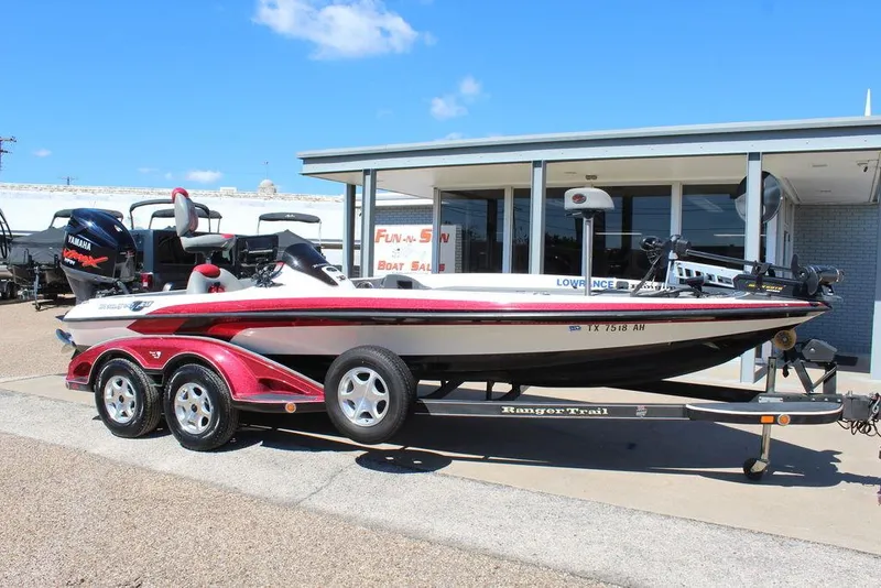 Slide: The Image of 2007 Ranger Z21 boat on trailer, parked outside a building under a clear blue sky. - 2