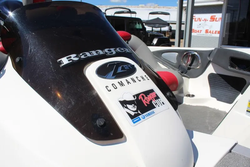 Slide: The Image of 2007 Ranger Z21 Comanche boat interior with branding and logos, displayed at a boat sales location. - 24