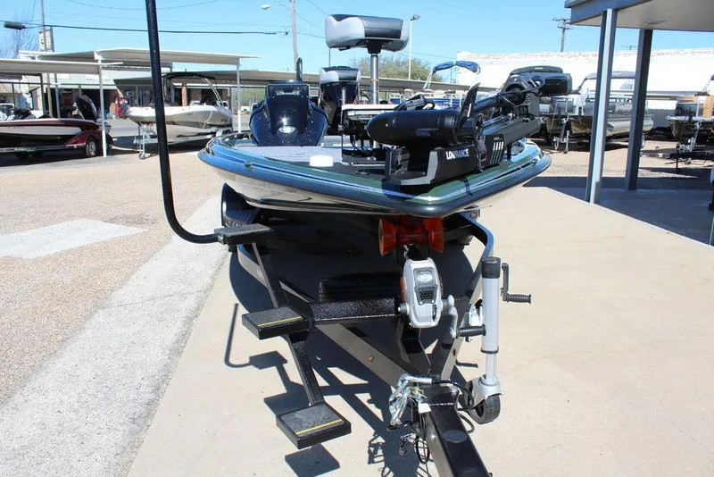 Slide: The Image of 2025 Phoenix 920 Elite II boat on trailer, parked outdoors in a marina setting. - 12