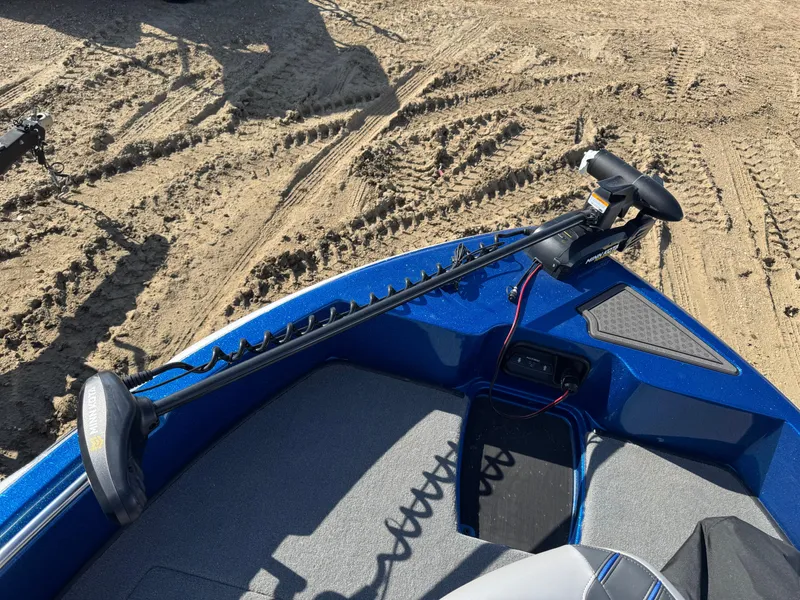 Slide: The Image of 2024 Nitro ZV19 Sport boat on sandy terrain, featuring a trolling motor. - 9