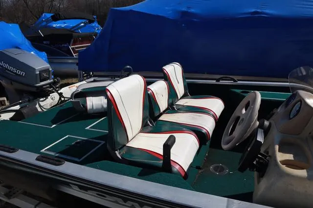 Slide: The Image of 1999 Lowe 170 boat interior with white and red seats, steering wheel, and Johnson outboard motor. - 4