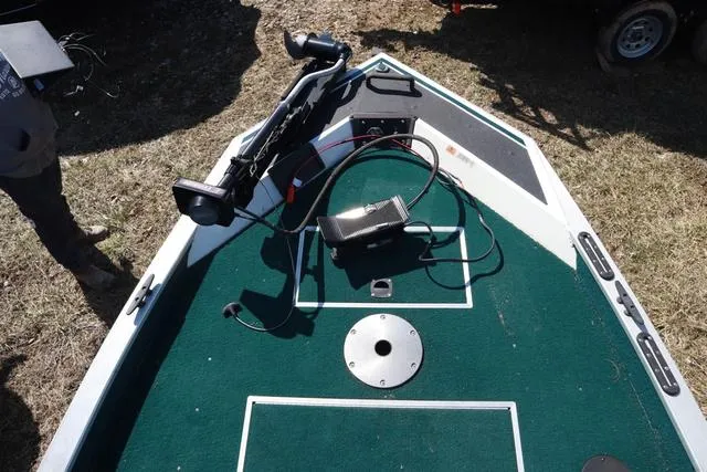 Slide: The Image of 1999 Lowe 170 boat deck with green carpet and fishing equipment. - 7