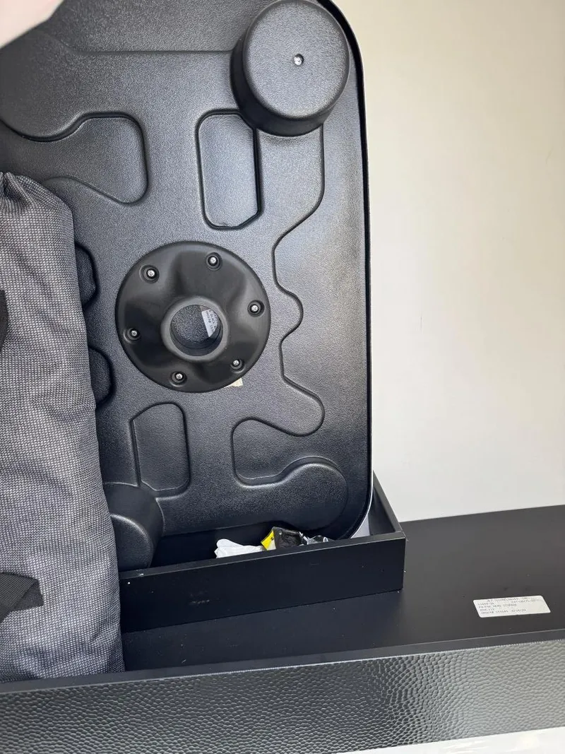 Slide: The Image of 2021 Yamaha Boats 252SE storage compartment with black cover and accessories. - 47