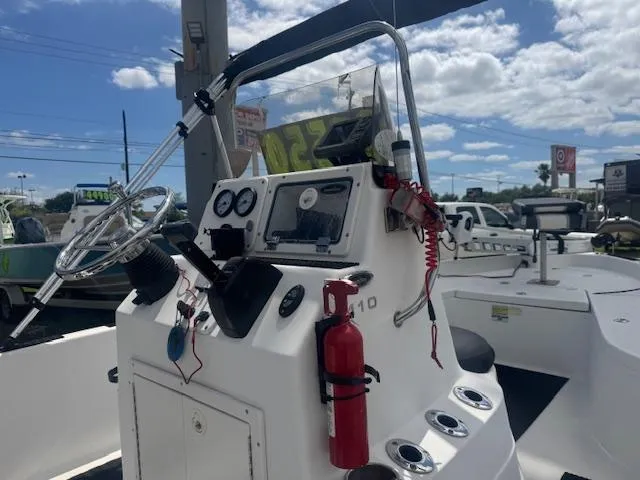 Slide: The Image of 2010 NauticStar 2110 Nautic Bay boat console with steering wheel and gauges under a blue sky. - 10