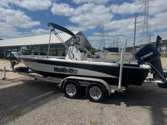 Slide: The Image of 2010 NauticStar 2110 Nautic Bay boat on trailer, parked outdoors under cloudy sky. - 3