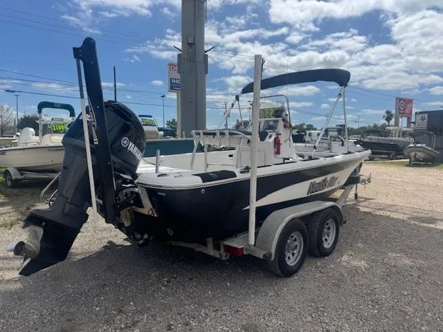 Slide: The Image of 2010 NauticStar 2110 Nautic Bay boat on trailer, parked outdoors under cloudy sky. - 5
