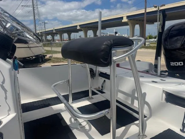 Slide: The Image of 2010 NauticStar 2110 Nautic Bay boat interior with seating and console, under a clear sky. - 9
