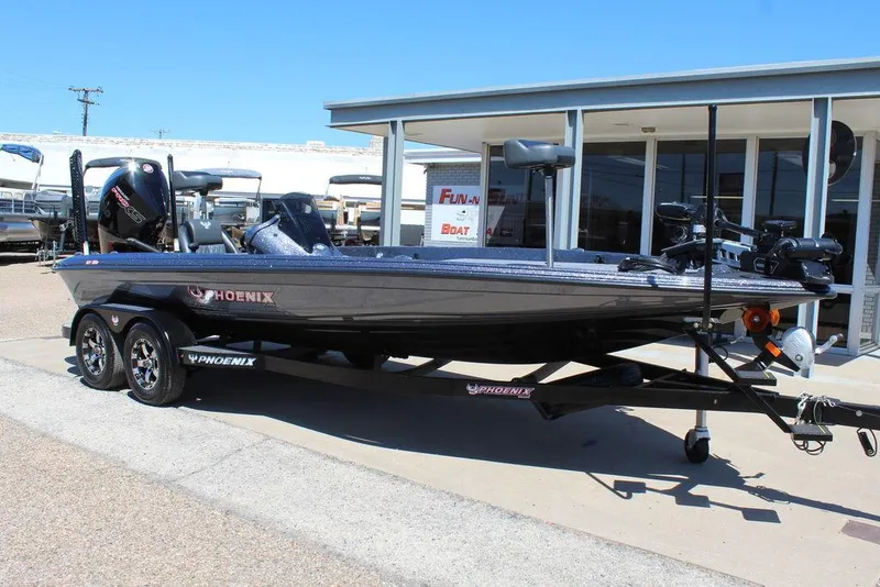 Slide: The Image of 2025 Phoenix 921 ELITE boat on trailer, parked outside dealership under clear blue sky. - 0