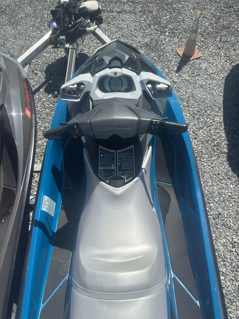 Slide: The Image of 2019 Sea-Doo GTI SE 130 jet ski, blue and gray, parked on gravel. - 1