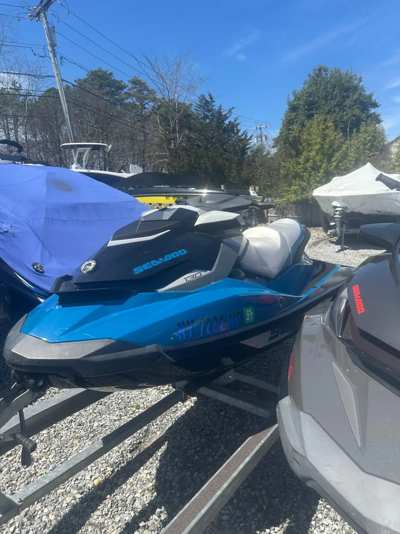 Slide: The Image of 2019 Sea-Doo GTI SE 130 jet ski in blue, parked on a trailer outdoors. - 3