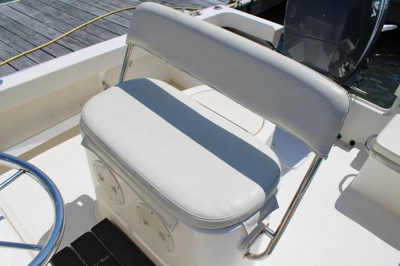 Slide: The Image of 2006 Parker 1801 Center Console boat seat with white cushioned bench and steering wheel. - 24