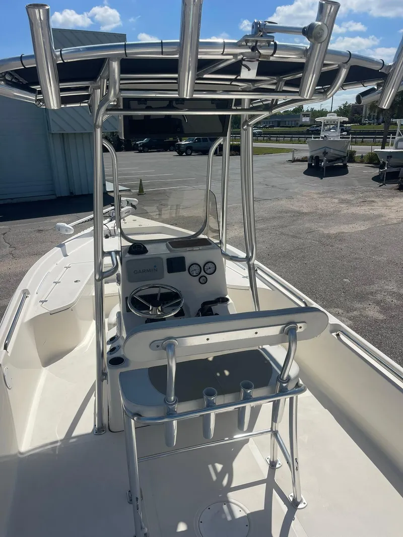 Slide: The Image of 2020 Bulls Bay 2400 boat with T-top and console, parked outdoors under blue sky. - 10
