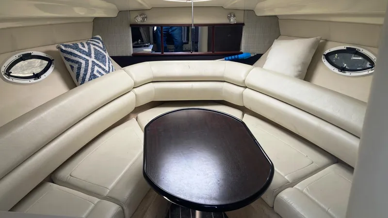 Slide: The Image of Interior of 2018 Monterey 275 Sport Yacht with beige seating and a central table. - 12