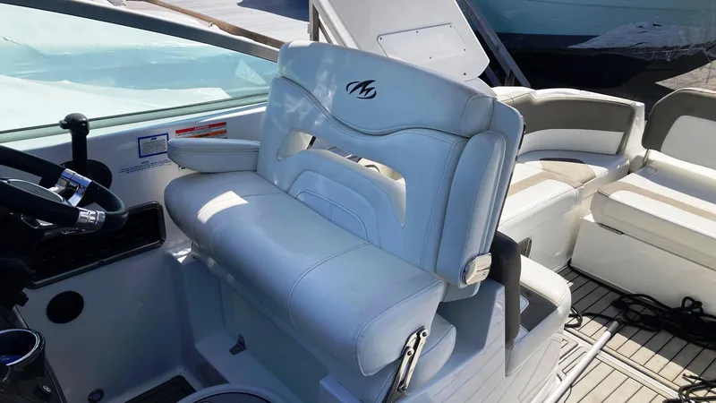 Slide: The Image of 2018 Monterey 275 Sport Yacht interior with white leather seating and steering wheel. - 7