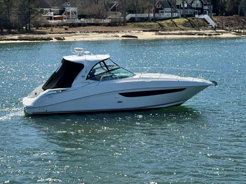 Slide: The Image of 2014 Sea Ray 370 Sundancer cruising on a sunny day near a shoreline. - 15