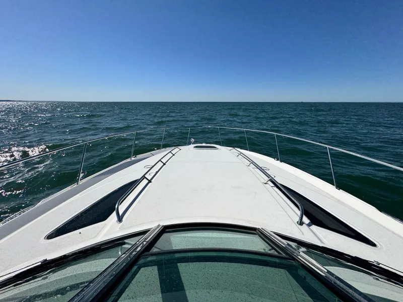Slide: The Image of 2014 Sea Ray 370 Sundancer cruising on open water under clear blue sky. - 16