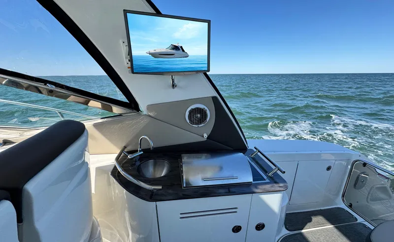 Slide: The Image of 2014 Sea Ray 370 Sundancer yacht interior with sink, TV, and ocean view. - 19