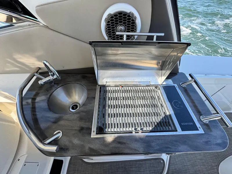 Slide: The Image of Outdoor kitchenette on 2014 Sea Ray 370 Sundancer with grill and sink, overlooking water. - 20