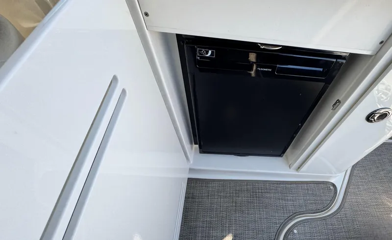 Slide: The Image of Compact refrigerator on 2014 Sea Ray 370 Sundancer yacht, featuring sleek white cabinetry. - 21