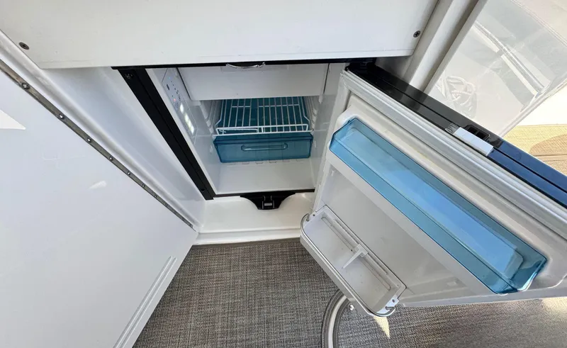 Slide: The Image of Open refrigerator on 2014 Sea Ray 370 Sundancer yacht, showcasing interior storage space. - 22