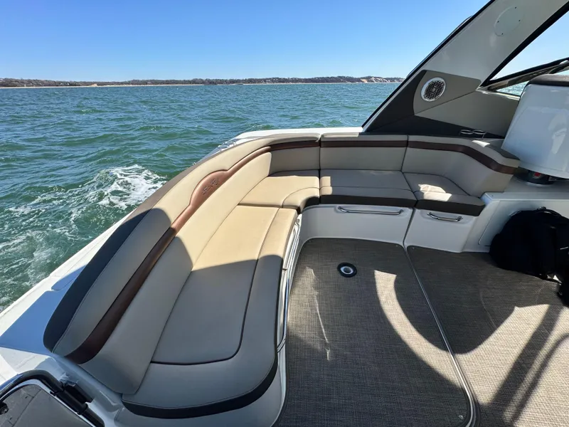 Slide: The Image of 2014 Sea Ray 370 Sundancer boat interior with beige seating, cruising on open water. - 23