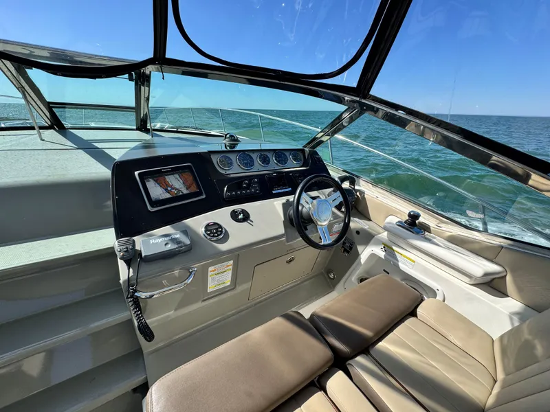 Slide: The Image of 2014 Sea Ray 370 Sundancer helm with ocean view, featuring modern controls and comfortable seating. - 27