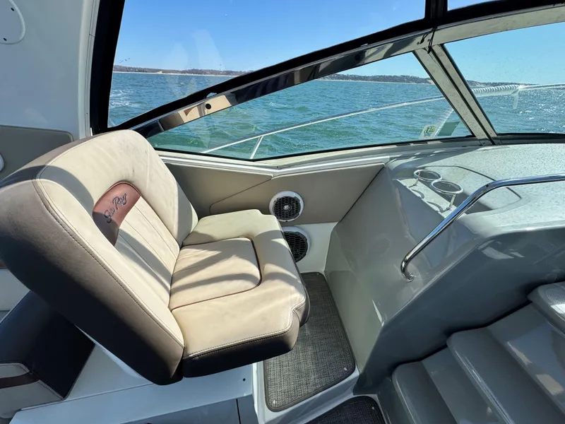 Slide: The Image of 2014 Sea Ray 370 Sundancer cockpit with beige seating, ocean view, and modern controls. - 34