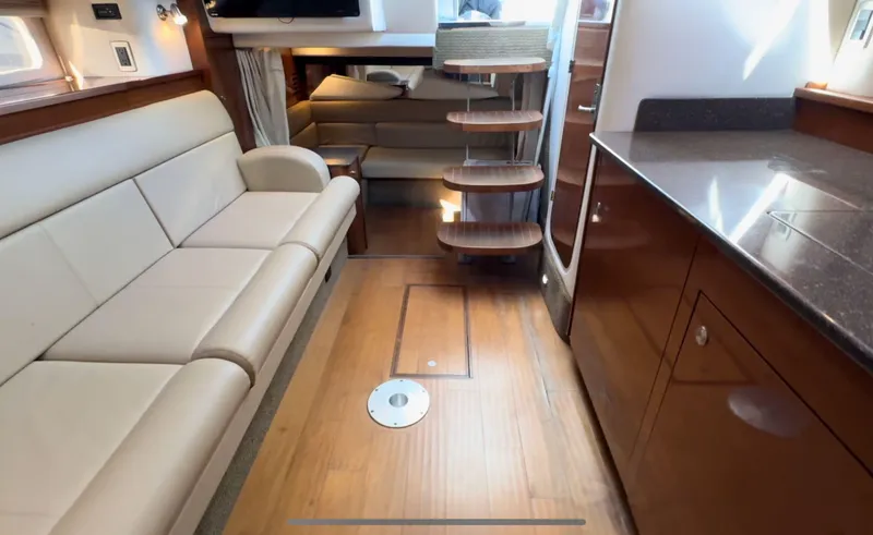 Slide: The Image of Luxurious interior of 2014 Sea Ray 370 Sundancer yacht with modern furnishings and wooden flooring. - 38