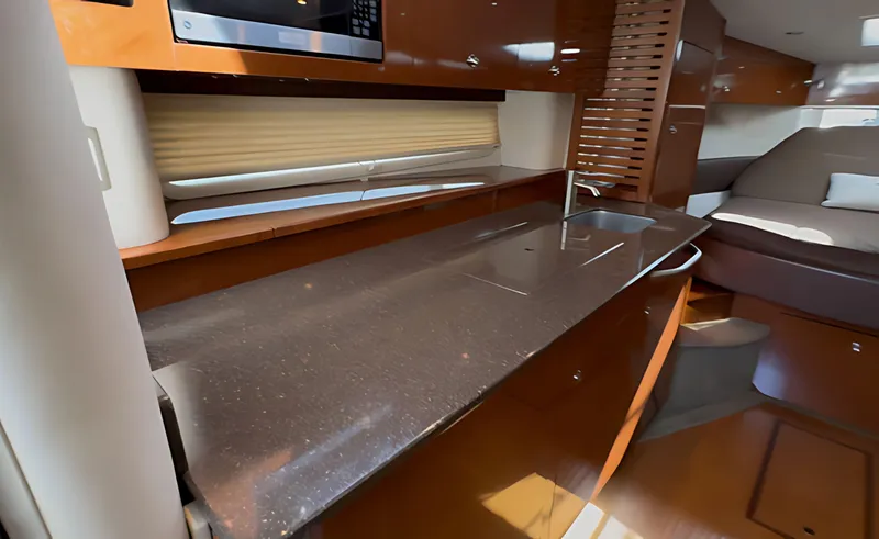 Slide: The Image of 2014 Sea Ray 370 Sundancer interior with sleek kitchen and cozy seating area. - 43