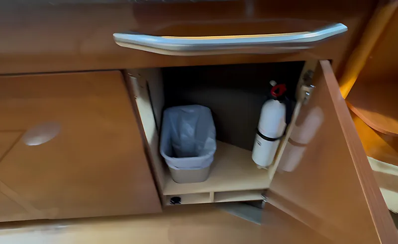 Slide: The Image of Cabinet interior on 2014 Sea Ray 370 Sundancer with trash bin and fire extinguisher. - 47