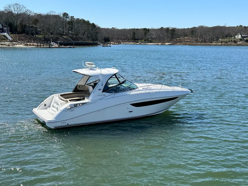 Slide: The Image of 2014 Sea Ray 370 Sundancer yacht cruising on a serene lake. - 8