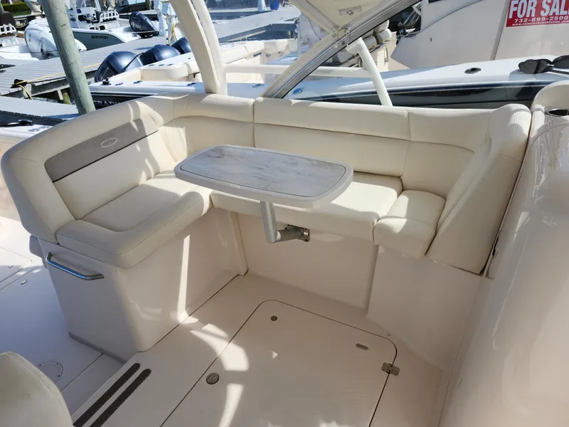 Slide: The Image of 2016 Grady-White Freedom 335 boat interior with cushioned seating and table. - 10