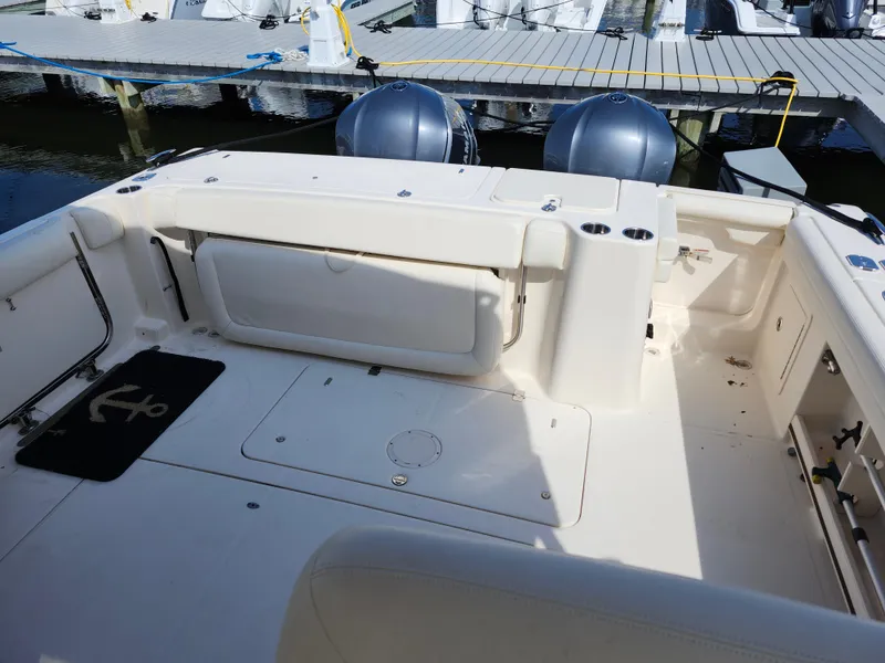 Slide: The Image of 2016 Grady-White Freedom 335 boat interior with twin engines and dock view. - 13