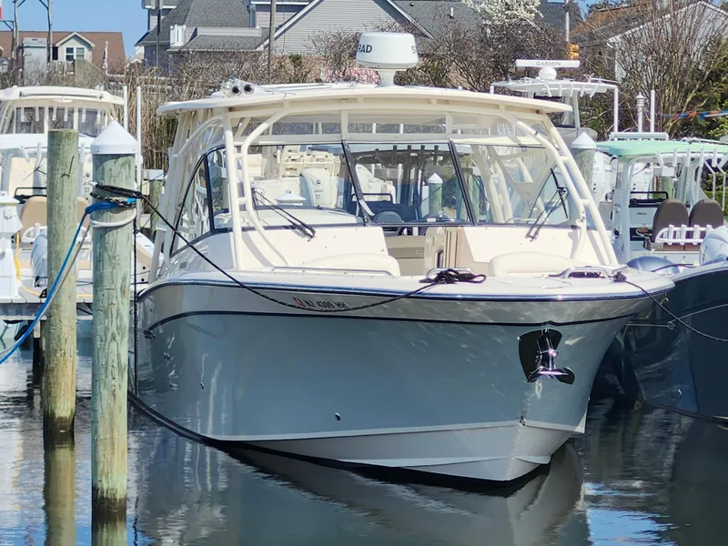 Slide: The Image of 2016 Grady-White Freedom 335 boat docked in marina, front view. - 2