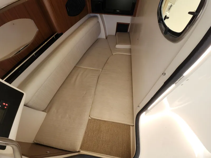 Slide: The Image of 2016 Grady-White Freedom 335 cabin interior with beige seating and porthole window. - 24