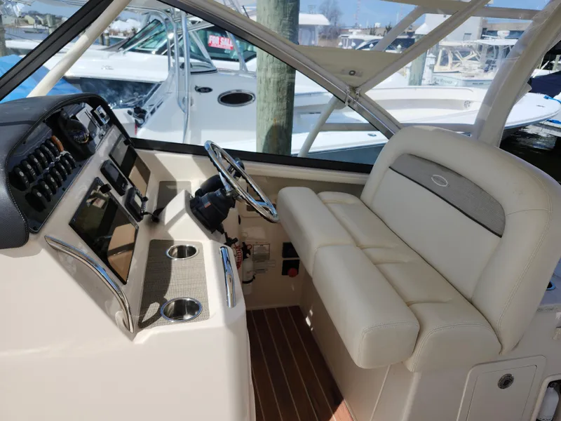 Slide: The Image of 2016 Grady-White Freedom 335 boat interior with steering wheel and seating. - 5