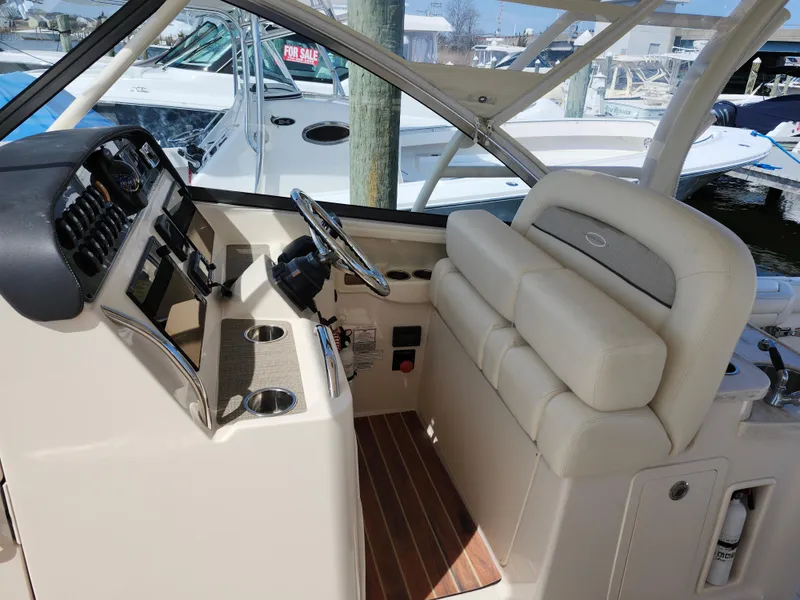 Slide: The Image of 2016 Grady-White Freedom 335 boat interior with helm, steering wheel, and seating. - 6