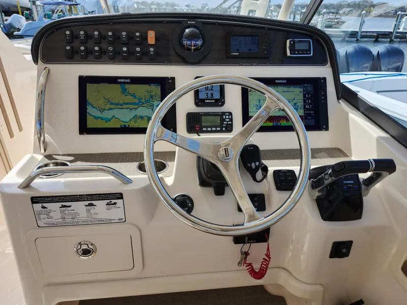 Slide: The Image of 2016 Grady-White Freedom 335 boat dashboard with navigation screens and steering wheel. - 7