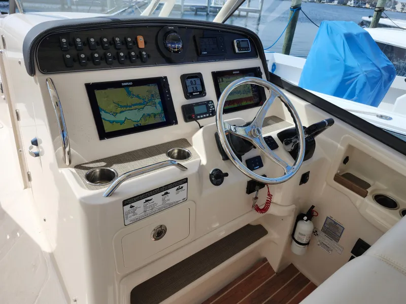 Slide: The Image of 2016 Grady-White Freedom 335 boat dashboard with navigation screens and steering wheel. - 8