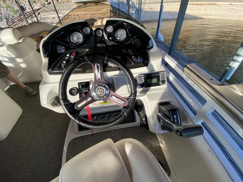 Slide: The Image of 2016 JC NepToon 23TT Sport boat dashboard with steering wheel and controls. - 19