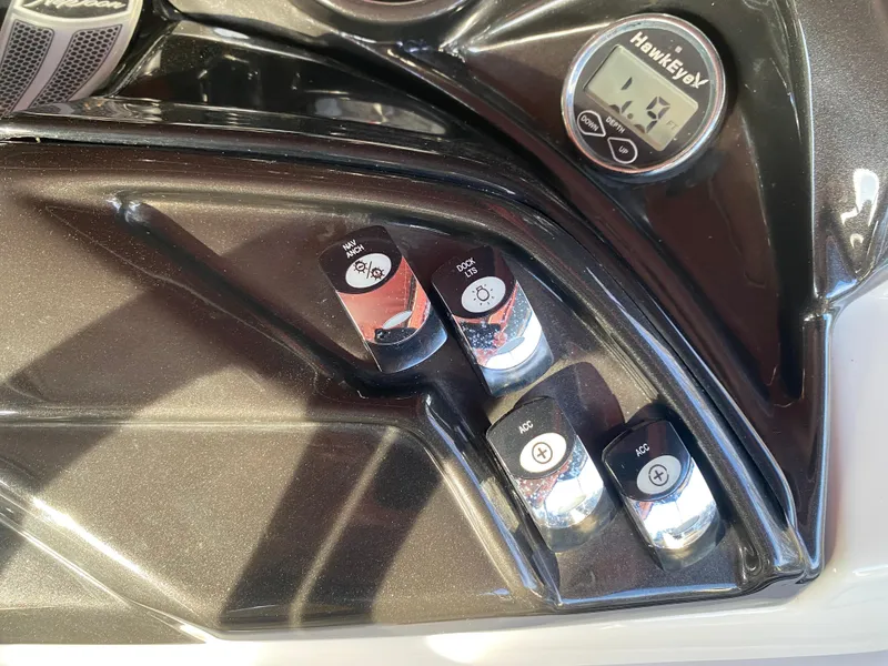 Slide: The Image of Control panel of a 2016 JC NepToon 23TT Sport boat with switches and a Hawkeye display. - 23