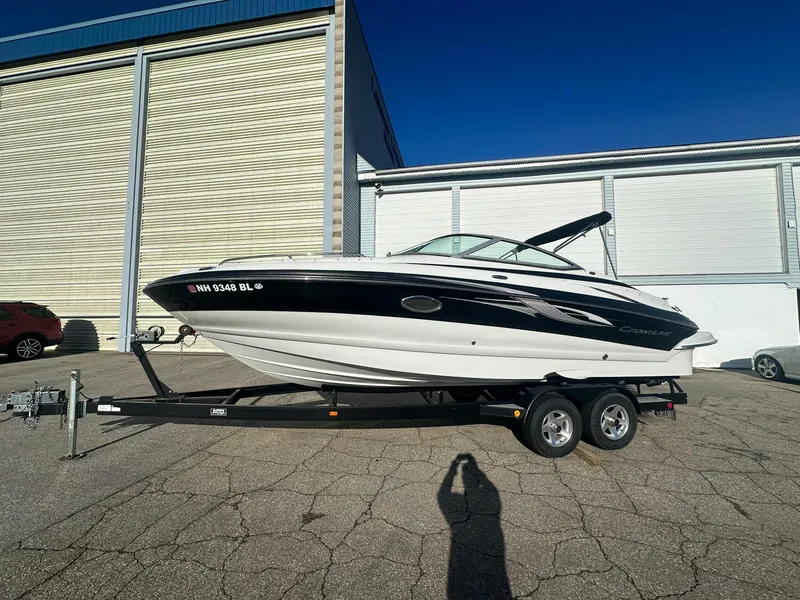 Slide: The Image of 2007 Crownline 260 LS boat on trailer, parked outside a warehouse. - 0