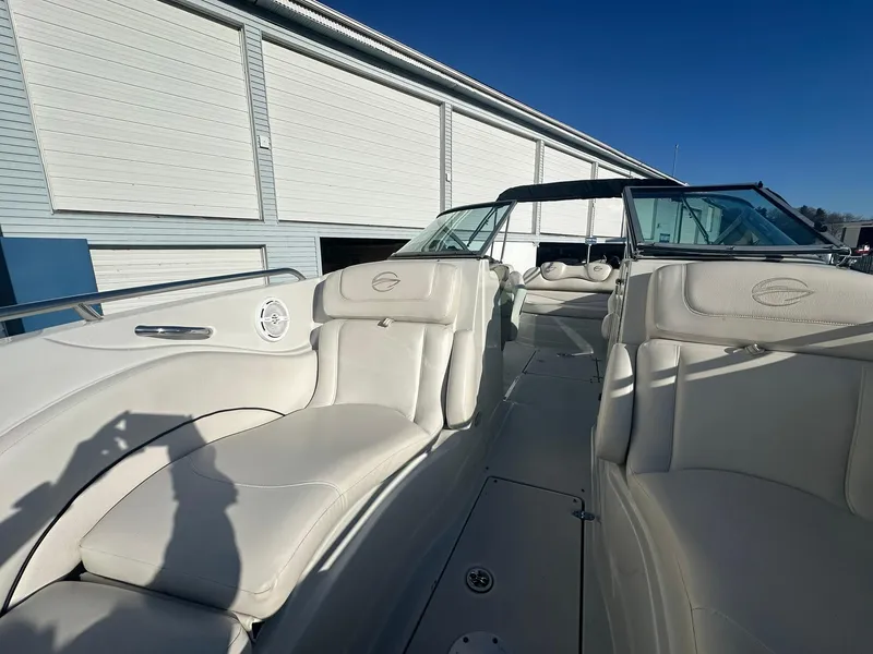 Slide: The Image of 2007 Crownline 260 LS boat with white leather seats, docked under clear blue sky. - 18