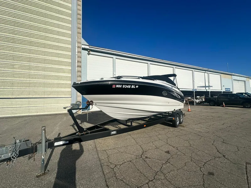 Slide: The Image of 2007 Crownline 260 LS boat on trailer, parked outside a warehouse under clear blue sky. - 4