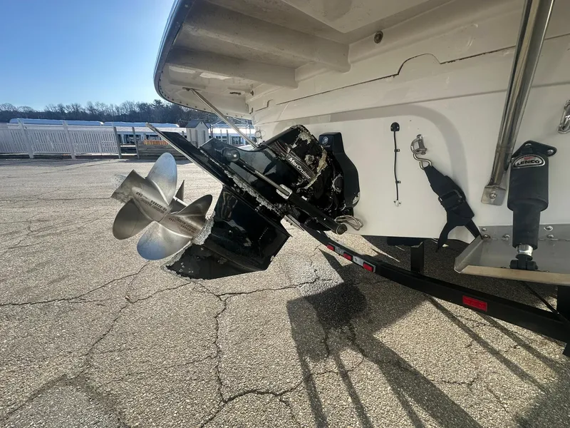 Slide: The Image of 2007 Crownline 260 LS boat stern with propeller and trailer, parked on pavement. - 7